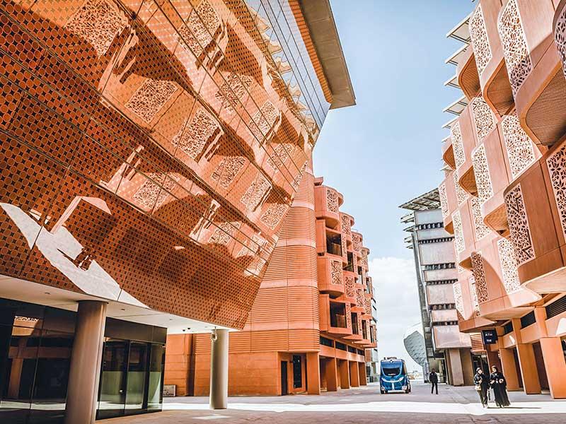 Rue de Masdar City avec façades protégées du soleil par des dispositifs d’ombrage et des écrans ajourés