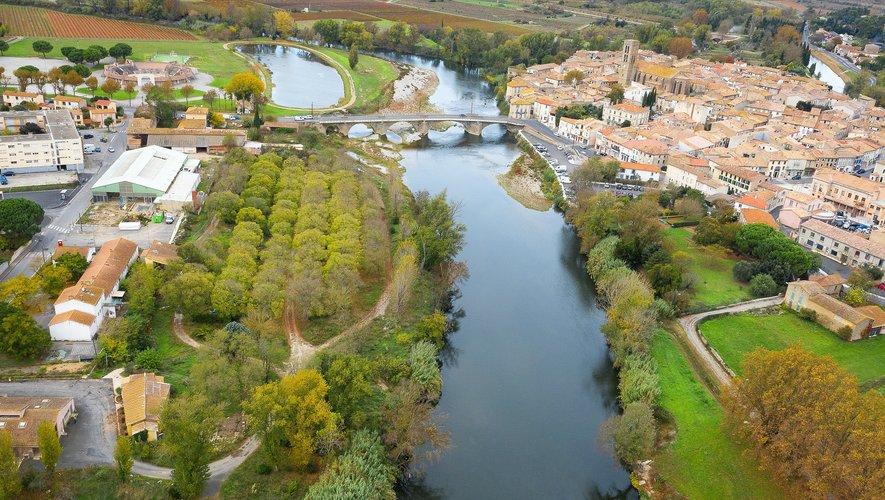 Vue aérienne de Trèbes et de l'Aude montrant le fleuve, le pont et les berges de la ville.